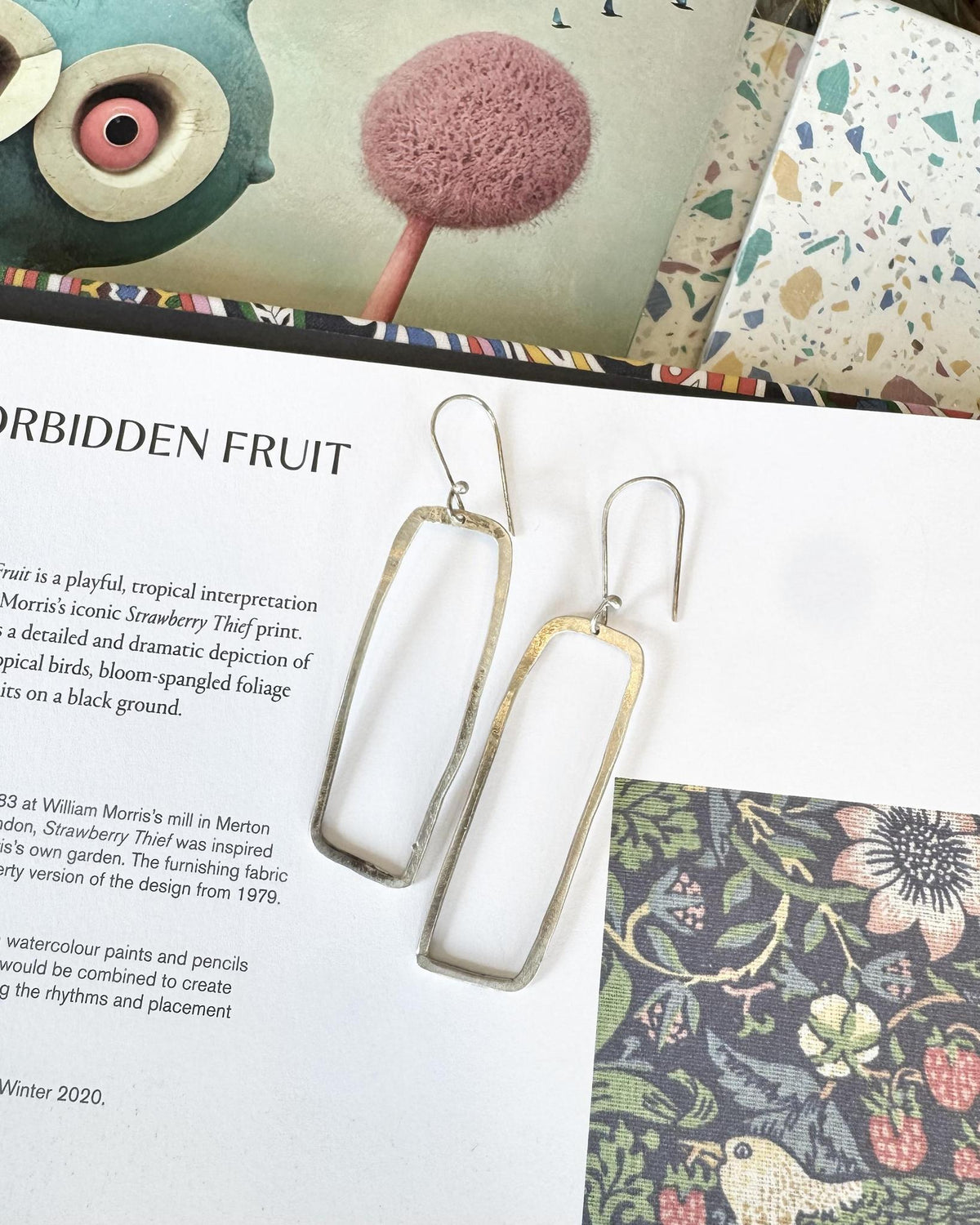 Modern in silhouette and organic in character, these elongated open rectangle earrings offer a distinctive take on classic sterling silver. Their simple geometric shape feels clean and architectural, while the hand-struck finish brings in the artist’s signature rough-hewn texture and natural, imperfect beauty.