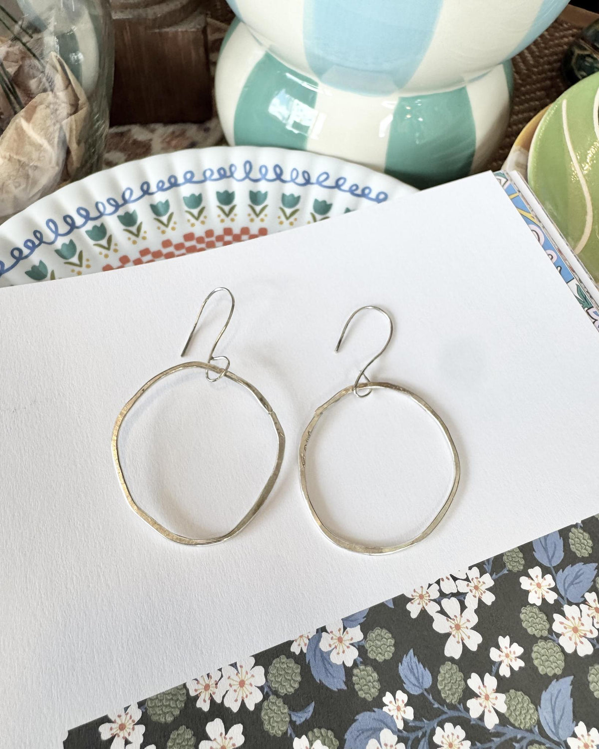 Simple, sculptural, and easy to wear, these medium-sized sterling silver circle earrings bring an organic touch to everyday style. Their clean circular form is softened by the distinctive rough-hewn character of hand-struck silver, giving this classic silhouette an authentic handmade presence.